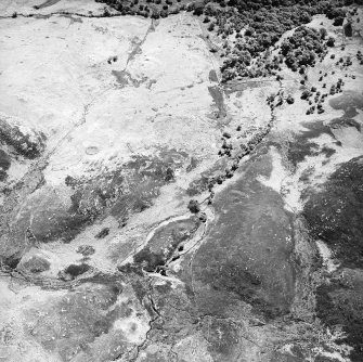 Morvich burn, oblique aerial view, taken from the NE, centred on a township. A hut-circle is visible in the bottom half of the photograph, and enclosures, a building and a structure are shown in the top-right hand corner.