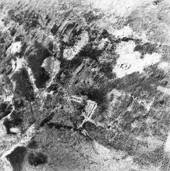 Oblique aerial view centred on the remains of the hut-circle and field system, taken from the ENE.