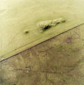 Oblique aerial view centred on the remains of the cairns, taken from the ENE.