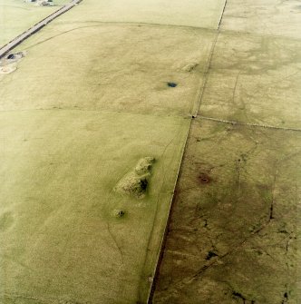 Oblique aerial view centred on the remains of the cairns, taken from the SE.