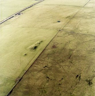 Oblique aerial view centred on the remains of the cairns, taken from the SE.