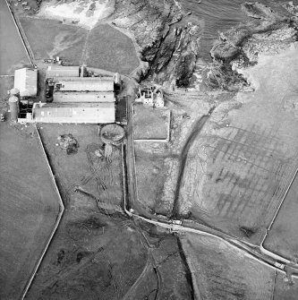 Oblique aerial view centred on the farmsteading and the remains of the tower-house, taken from the S