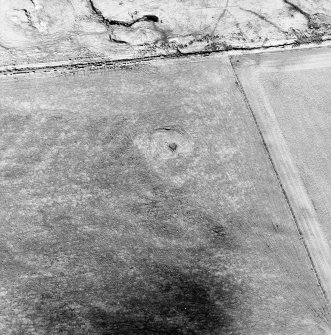Oblique aerial view centred on the remains of the cairn, taken from the SE.