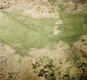 Oblique aerial view centred on the remains of the farmstead and field system with dun, settlement, hut-circle and burnt mounds adjacent, taken from the W.