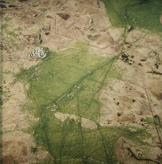 Oblique aerial view centred on the remains of the farmstead and field system with dun, settlement and burnt mounds adjacent, taken from the SSE.