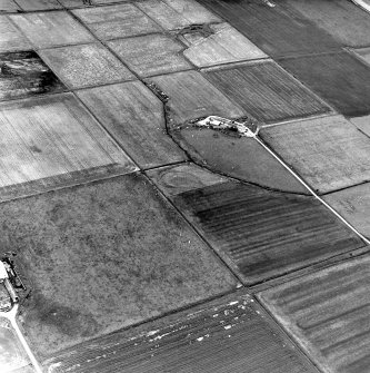 Carin of Humster, oblique aerial view, taken from the SE, showing  the remains of a broch in the centre of the photograph, and the farmstead of Blind Burn in the upper right-hand corner