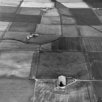 Carin of Humster, oblique aerial view, taken from the SW, showing the remains of a broch in the centre of the photograph.