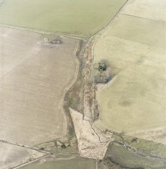 Oblique aerial view centred on the remains of the chapel and graveyard, taken from the SE.