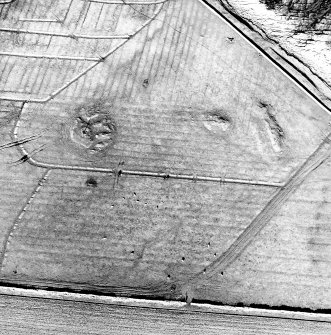 Oblique aerial view centred on the remains of the cairns and rig, taken from the SE.