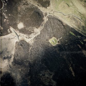 Oblique aerial view centred the remains of the chambered cairn and the dam, taken from the SW.