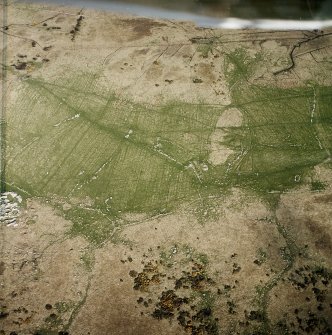 Oblique aerial view centred on the remains of the farmstead and field system with dun, settlement, hut-circle and burnt mounds adjacent, taken from the W.