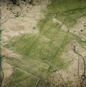 Oblique aerial view centred on the remains of the farmsteads, field system and burnt mounds, taken from the SE.