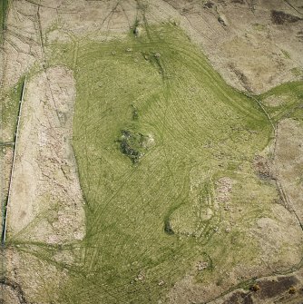 Oblique aerial view centred on the remains of the broch, rig and lazy bedding, taken from the N.