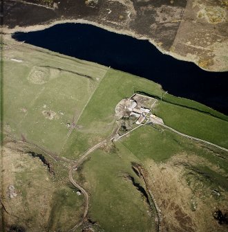 Oblique aerial view of the remains of the brochs and cairn, taken from the W.