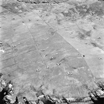 Stroma, oblique aerial view, taken from the E, centred on Uppertown township. A burial vault and dovecot are visible in the bottom left-hand corner of the photograph.