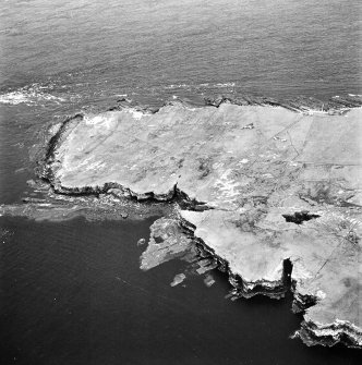 Stroma, oblique aerial view, taken from the W, centred on Bught o' Camm promotory fort and, showing Nethertown township in the centre right of the photograph.