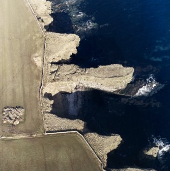 Oblique aerial view centred on the remains of the broch, taken from the SE.