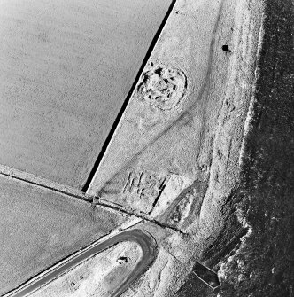 Oblique aerial view of the remains of the broch, buildings, pillbox and slipway, taken from the SSW.