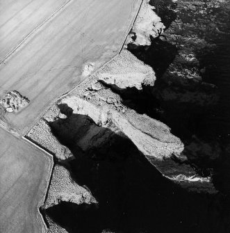 Oblique aerial view centred on the remains of the broch, taken from the E.