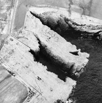 Oblique aerial view centred on the remains of the broch, taken from the SE.