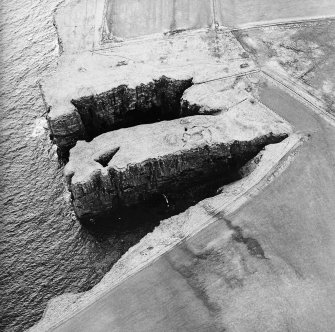 Oblique aerial view centred on the remains of the broch, taken from the N.