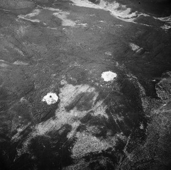 Oblique aerial view centred on the remains of the cairns and boundary stone, taken from the NE.