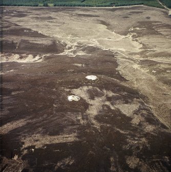 Oblique aerial view centred on the remains of the cairns and boundary stone, taken from the ENE.