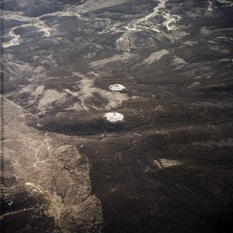 Oblique aerial view centred on the remains of the cairns and boundary stone, taken from the WNW.