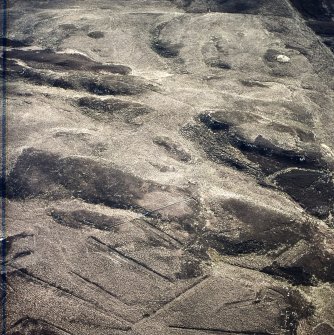Oblique aerial view centred on the remains of the fort and cairn, taken from the W.