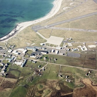 Oblique aerial view centred on the village with the airfield adjacent, taken from the S.