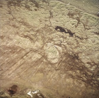 Oblique aerial view centred on the remains of the aisled round houses with the military installation adjacent, taken from the SW.