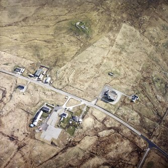 Oblique aerial view centred on the church and school with the mission hall and remains of the chambered cairn and sheepfold adjacent, taken from the WSW.