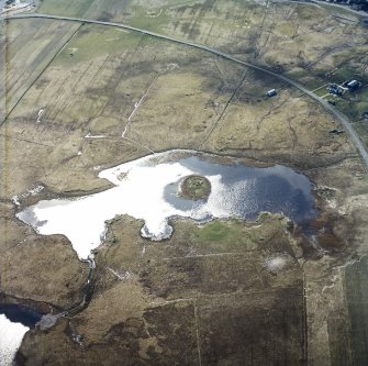 Oblique aerial view centred on the remains of the dun, taken from the NE.