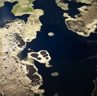 Oblique aerial view centred on the remains of the duns, taken from the SSE.