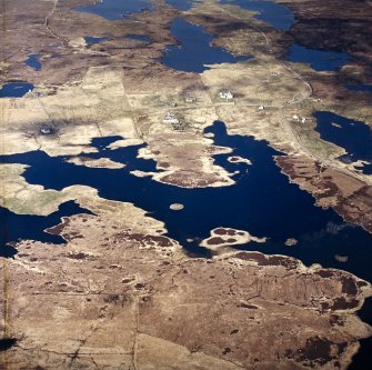Oblique aerial view centred on the remains of the duns, with the crofting township adjacent, taken from the SW.