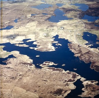 Oblique aerial view centred on the remains of the duns, with the crofting township adjacent, taken from the SSW.