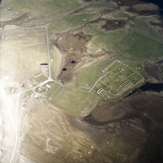 Oblique aerial view centred on the burial-ground and the remains of the church, taken from the SW.