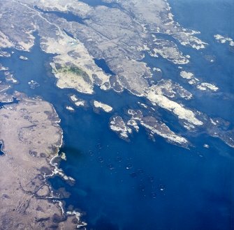 Oblique aerial view centred on the fish farm (NF 8757 4883) with the house adjacent, taken from the SSE.