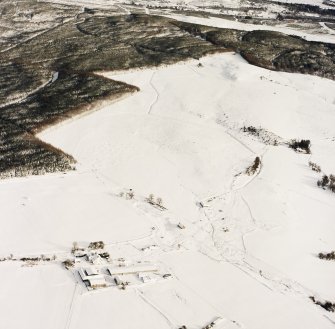 Oblique aerial view of Upperton centred on the remains of hut-circles and a field-system with the same and small cairns and a field bank adjacent, taken from the SW.