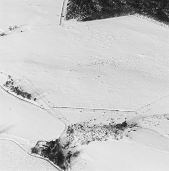 Oblique aerial view of Upperton centred on the remains of hut-circles and a field-system with the same adjacent, taken from the SE.