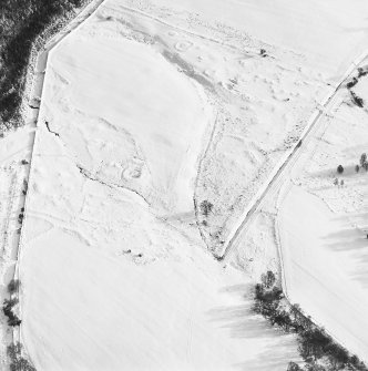 Oblique aerial view of Upperton centred on the remains of hut-circles and a field-system with cairns adjacent, taken from the WNW.