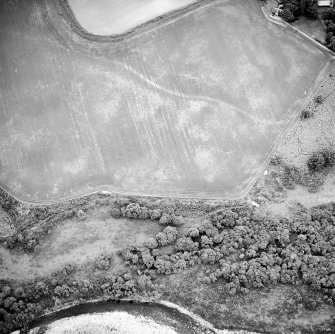 Oblique aerial view centred on the cropmarks of the ring-ditch, taken from the ESE.