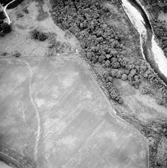 Oblique aerial view centred on the cropmarks of the ring-ditch, taken from the SW.