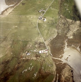 Oblique aerial view centred on the cottage with the manse and the remains of the church adjacent, taken from the WNW.
