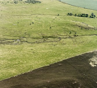 Oblique aerial view of Garbeg centred on the remains of hut-circles, buildings, field-systems and small cairns, taken from the NW.