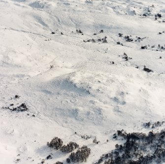 Oblique aerial view of Garbeg centred on the remains of hut-circles, a field-system, small cairns and rig, taken from the NW.