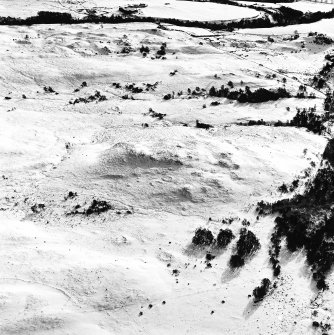 Oblique aerial view of Garbeg centred on the remains of hut-circles, a field-system and small cairns with the same and rig adjacent, taken from the NNW.