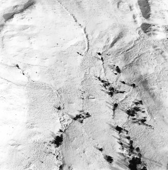 Oblique aerial view of Garbeg centred on the remains of hut-circles, a field-system, small cairns and rig, taken from the SW.