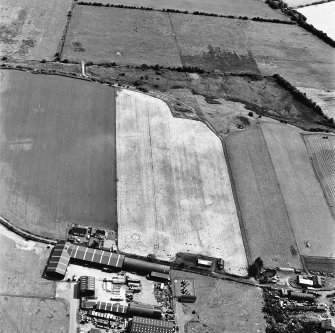 Windhill, oblique aerial view, taken from the NW, centred on the cropmarks of a ring-ditch and a possible pit-circle.