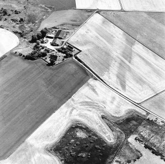 Gilchrist, oblique aerial view, taken from the NW, centred on the cropmarks of a promontory fort. Kilchrist Church is visible in the top left-hand corner of the photograph.
